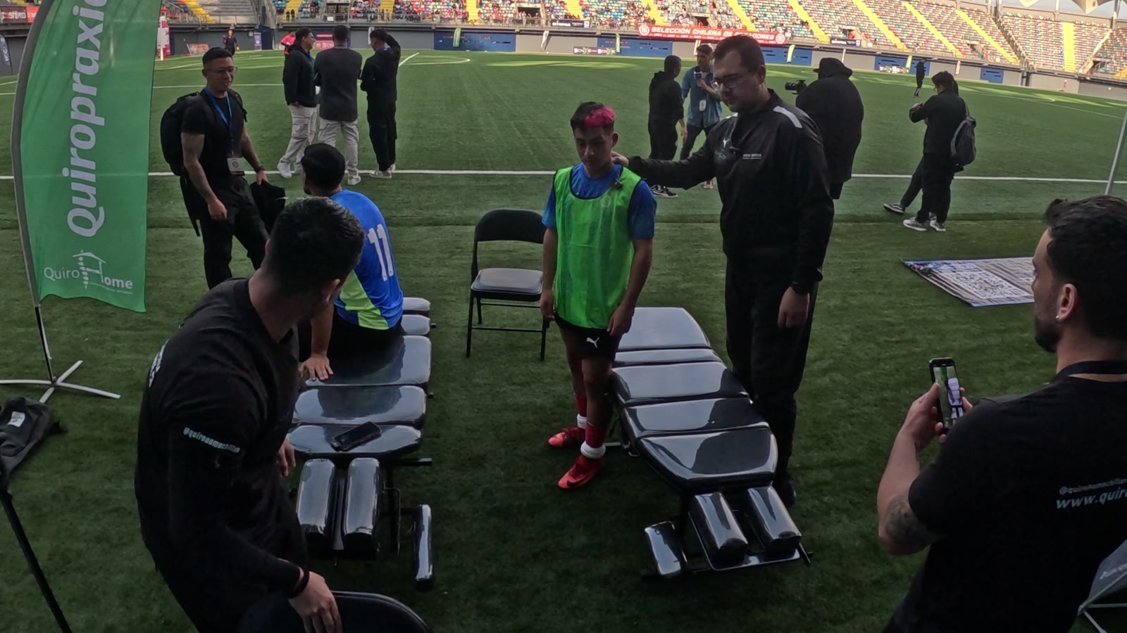 Jugadores llegando a la zona de atención de QuiroHome en el borde de la cancha